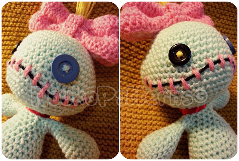 May include: A crocheted blue Stitch doll with pink yarn hair and a pink bow. The doll has black yarn stitching around the eyes and mouth, and blue and black buttons for eyes.