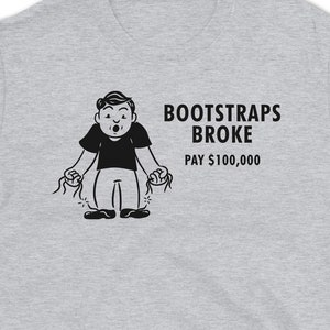 Puede incluir: Una camiseta gris con una ilustración de dibujos animados en negro de una persona con las correas de las botas rotas. El texto "BOOTSTRAPS BROKE PAY $100,000" está impreso debajo de la ilustración.