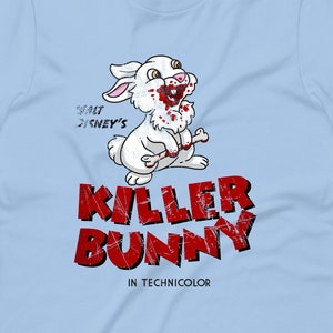 May include: Pale blue t-shirt with a cartoon bunny design. The bunny has blood around its mouth and paws. Below the bunny is the text "KILLER BUNNY" in a distressed red font, with "IN TECHNICOLOR" underneath. The shirt also has the text "WALT DISNEY'S" above the bunny.