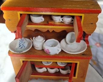 Aparador de cozinha vintage alemão para casa de bonecas, estilo folk art, com louça de porcelana antiga. Pintado à mão no estilo Dora Kuhn. Falta um pé traseiro.