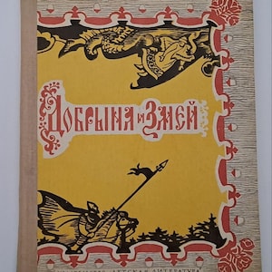 Pode incluir: Um livro de capa dura com uma capa amarela apresentando uma ilustração em preto e vermelho de um cavaleiro montado com uma lança. O título Dobrynya i Zmey está impresso em letras cirílicas vermelhas. Inclui Izdatelstvo Detskaya Literatura.