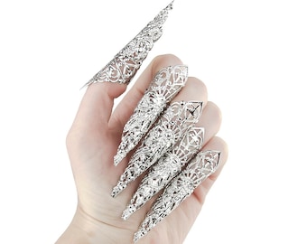 Puede incluir: Un conjunto de cinco anillos de garra de filigrana plateada. Los anillos están diseñados para ajustarse sobre la uña y son puntiagudos en la punta.