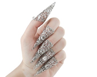 May include: A set of five silver filigree claw rings. The rings are designed to fit over the fingernail and have a pointed tip.