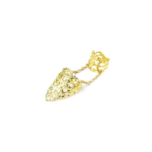 May include: Gold filigree ring with a chain connecting two rings. The ring is designed to be worn on two fingers.