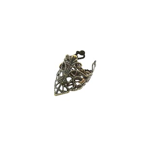 May include: A gold-toned filigree ring with a pointed design. The ring is made of metal and has a delicate, intricate pattern.