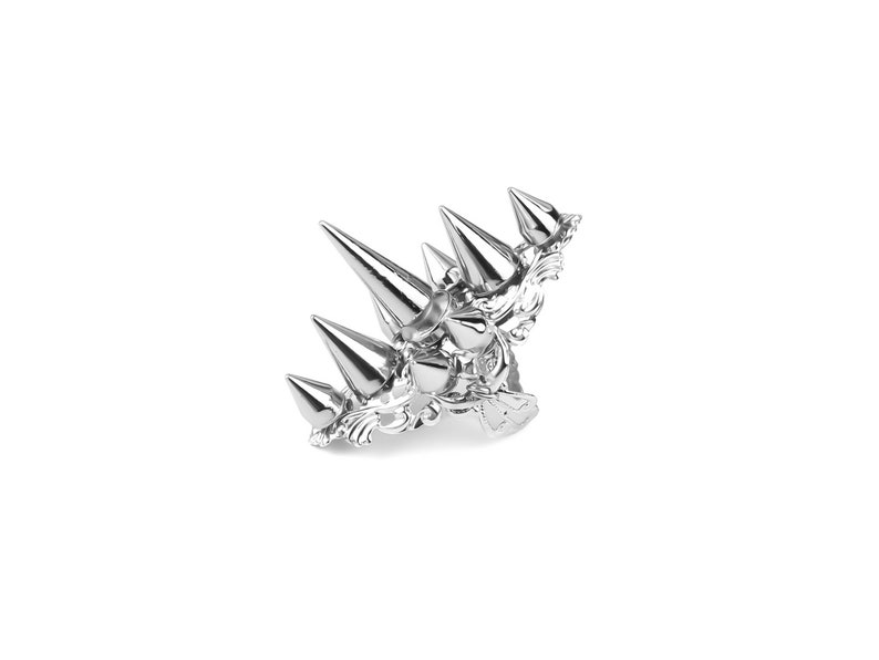 Pu&ograve; includere: Una corona d'argento con un design decorativo e punte affilate. La corona &egrave; in metallo e ha una finitura lucida.
