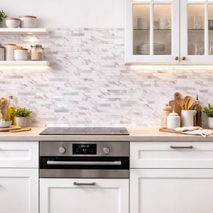 May include: A white ceramic mug with a black handle and the text "But First, Coffee" in a bold, black font. The mug is set against a neutral background, highlighting its simple design.