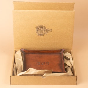 The tray packaged in a simple brown cardboard box, nestled in brown packing paper. The box opens from the top and displays the Wizened Oak Leather logo on the inside of the lid.