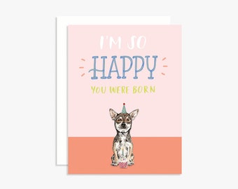 May include: A birthday greeting card with a pink and coral background. The text "I'M SO HAPPY YOU WERE BORN" is displayed in white and blue. A Chihuahua wearing a party hat and holding a cupcake is featured.