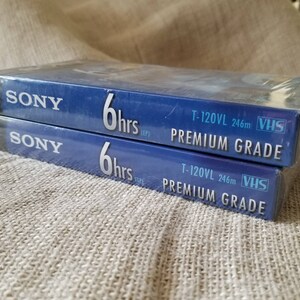 May include: Two blue VHS tapes with the Sony logo and the text "6 hrs (EP)" and "T-120VL 246m VHS PREMIUM GRADE".