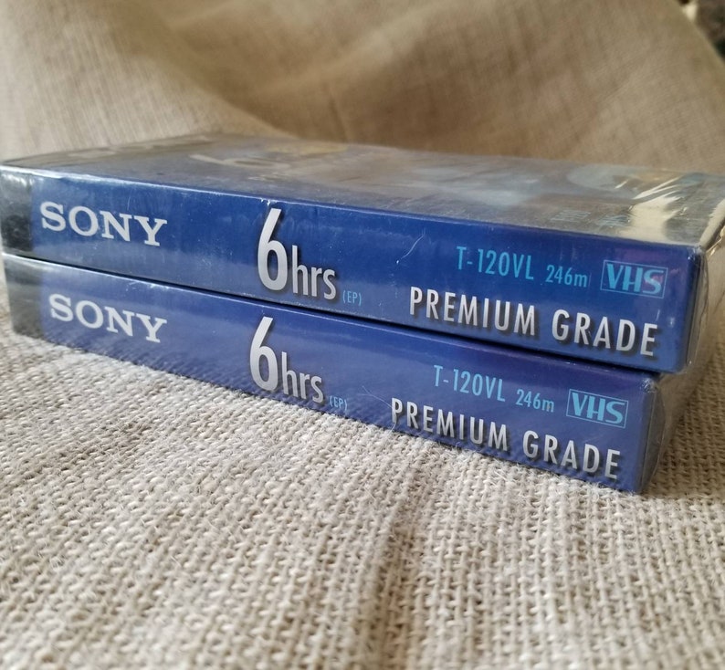 May include: Two blue VHS tapes with the Sony logo and the text "6 hrs (EP)" and "T-120VL 246m VHS PREMIUM GRADE".