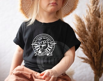 May include: A black t-shirt with a white graphic design featuring a fist holding a lightning bolt. The graphic is surrounded by a circle with the text "High Voltage Line Life".