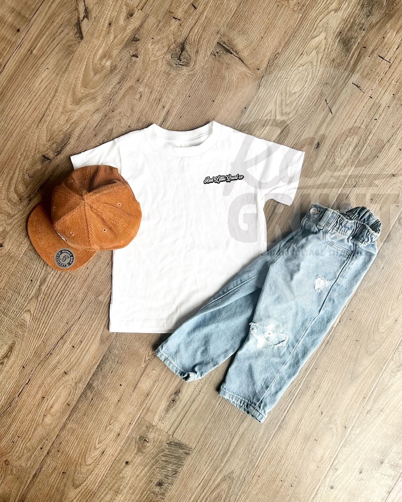 Peut inclure: Un t-shirt blanc avec le texte "And Little Souls" en noir, associ&eacute; &agrave; un jean bleu clair d&eacute;chir&eacute; et une casquette de baseball en velours c&ocirc;tel&eacute; marron. La casquette a un &eacute;cusson circulaire.