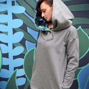 Oversize long grey hoodie with printed lining. Monstera print