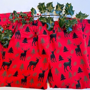May include: Red pyjama trousers with a black and green reindeer and pine tree pattern.