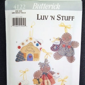 May include: A Butterick pattern for Christmas ornaments. The pattern includes instructions for making gingerbread people and a house ornament. The ornaments are decorated with fabric scraps, buttons, and ribbons. The text "Luv 'N Stuff" is at the top.