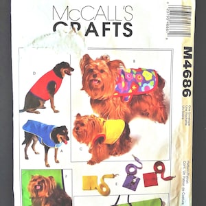 May include: McCall's Crafts pattern for dog clothing. The pattern features illustrations of dogs wearing various outfits, including coats and vests. The pattern also includes accessories like leashes and bags. The cover is white with the text "McCall's Crafts".
