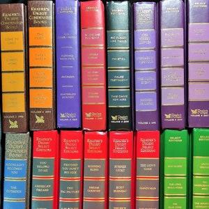 May include: A collection of Reader's Digest Condensed Books and Select Editions. The books have various colored spines, including brown, purple, red, green, and blue. Titles are in gold lettering, with some volumes dated.