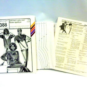 May include: Vintage sewing pattern from Stretch & Sew featuring a patched rugby and flower applique design. The pattern includes instructions and illustrations for creating the garments. The cover has a retro design with models wearing the outfits.