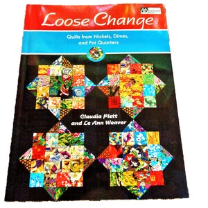 May include: A book cover titled "Loose Change" with a red and blue banner. The cover features colorful quilt block designs. The book is about quilts made from nickels, dimes, and fat quarters, by Claudia Plett and Le Ann Weaver.