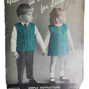 May include: Vintage book cover with the title "Fashions in Wool for Little Tots." The cover features two children wearing hand-knitted garments. The boy wears a teal vest, and the girl wears a teal dress. The book is Volume 115 and includes simple instructions.