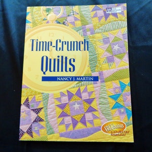 May include: A book titled "Time-Crunch Quilts" by Nancy J. Martin. The cover features a yellow background with a clock design and a colorful quilt pattern. A "FREE bonus CD-ROM inside!" sticker is in the lower right corner.