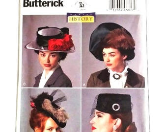 May include: A vintage sewing pattern titled "B6397 Butterick" featuring four images of women wearing historical hats. The hats include a black hat with a silver brim and red flowers, and a black hat with a veil.
