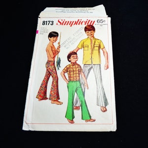 May include: A vintage Simplicity sewing pattern packet, featuring illustrations of boys in flared pants and shirts. The packet is labeled "8173" and includes text indicating size and fabric details. The design evokes a retro aesthetic.