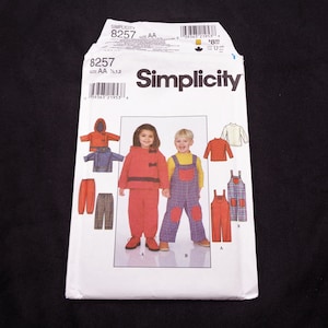 May include: A Simplicity sewing pattern packet, style 8257, featuring children's clothing designs. The packet displays illustrations of outfits, including a red hooded jacket and pants, and overalls. The size is AA.