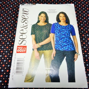 May include: A sewing pattern package featuring two women modeling tops and pants. The package has the text "see & sew" and "YES! it's easy". The tops are short-sleeved, one with a lace design and the other with a pixelated pattern.