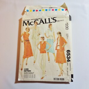 May include: Vintage McCall's 6534 sewing pattern. The pattern envelope features illustrations of women's clothing designs, including a skirt suit, pantsuit, and wrap top. The envelope is cream-colored with the text "McCall's" and "6534".