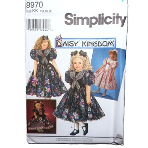 May include: Simplicity sewing pattern featuring a Daisy Kingdom design. The pattern includes illustrations of girls' dresses with floral prints and puff sleeves. The package has the text "9970" and size information.