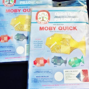 May include: Two pre-quilted pillow kits in plastic packaging. The kits feature a fish design labeled "MOBY QUICK" and include instructions. The packaging has a blue and white color scheme with the "COLORTEX" logo.