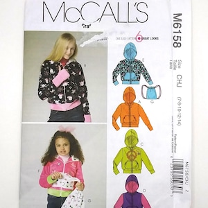 May include: McCall's sewing pattern for children's hoodies. The pattern features six different hoodie designs, including a floral print, solid colors, and a drawstring bag. The pattern size range is 7-8-10-12-14.