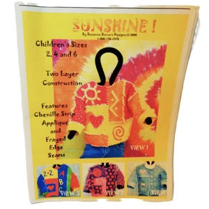 May include: A yellow and white paper with the word "SUNSHINE!" at the top. The paper features a colorful children's sweater design with the text "Children's Sizes 2, 4 and 6". The design includes chenille strip applique and frayed edge seams.