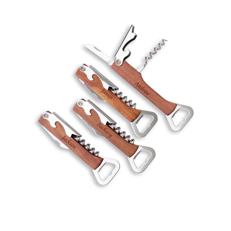 May include: Four personalized wooden wine opener tools with stainless steel components. Each opener features a corkscrew, bottle opener, and knife. The names "Andrew", "James", "Zachary", and "Jackson" are engraved on the wooden handles.