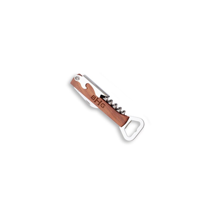 A silver and wood multi-tool with a corkscrew, bottle opener, and knife. The tool is engraved with the letters "BHG".