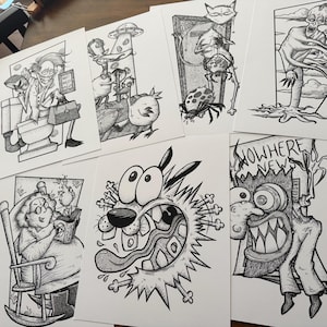 May include: A collection of black and white cartoon art prints featuring characters and scenes from the animated series "Courage the Cowardly Dog." The prints showcase various characters in detailed, stylized illustrations.