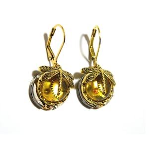May include: Gold tone earrings with a dragonfly design and a round, amber-colored glass cabochon. The cabochon features a small, gold-toned gear inside.