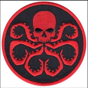 May include: Red and black embroidered patch with a skull and tentacles, resembling a hydra. The skull has a menacing expression with two eye sockets and a prominent jaw.