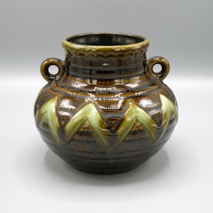 May include: A brown ceramic vase with green geometric designs and two handles. The vase has a glossy finish.