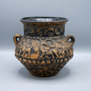 May include: A brown ceramic vase with black accents and a raised design of animals. The vase has two handles and a rounded body.