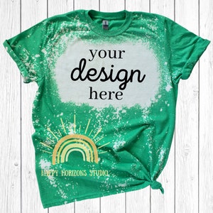 May include: Green t-shirt with bleach splatters and a rainbow design. The text "your design here" is printed on the shirt.