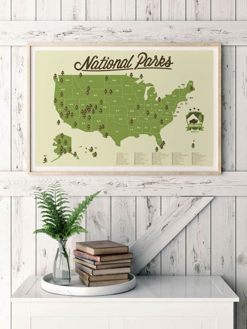 May include: A green and brown map of the United States with the text "National Parks" at the top. The map shows the location of all 63 national parks in the United States. The map is framed and hanging on a white wooden wall.