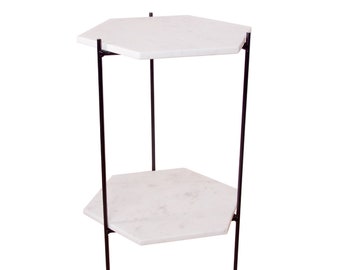 May include: A white marble hexagonal side table with a black metal frame. The table has two shelves.