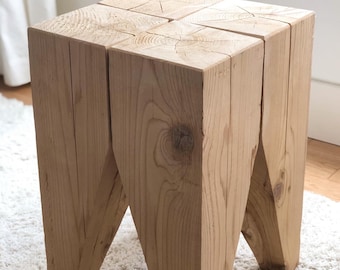 May include: A wooden stool with a square top and four legs. The legs are angled and the wood has a natural finish.