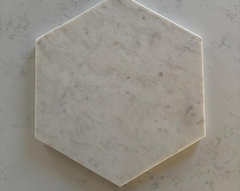 May include: White marble hexagon serving tray with a light gray veining pattern.