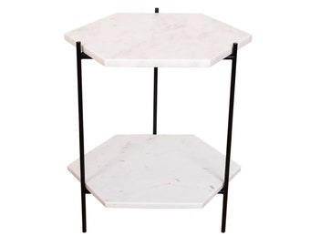 May include: A white marble hexagonal side table with a black metal frame. The table has two tiers.