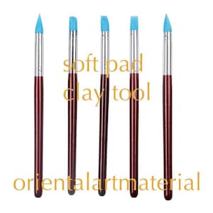 Könnte beinhalten: Fünf blaue und weiße Keramik-Modellierwerkzeuge mit Holzgriffen. Die Werkzeuge sind mit "soft pad clay tool" beschriftet.