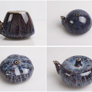 Puede incluir: Un juego de cuatro pequeñas teteras de cerámica con un esmalte azul y negro. Las teteras tienen un cuerpo redondo y un pequeño pico.